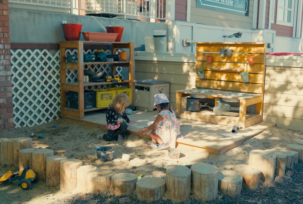 Children exploring sand in the Kettle Valley yard